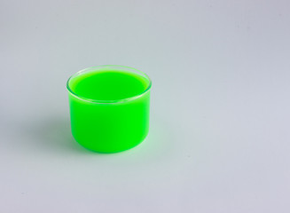 Jar with a toy called green slime on a light background. Funny toy for children's leisure and creativity. Selective focus.