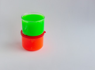 Multi-Coloured toy called slime on a light background..Plastic jars with fun toy for children's...
