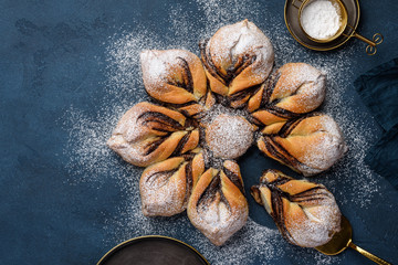 Delicious chocolate star bread on a blue background. Twisted pie. Top view.  Copy space 