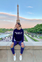 A young woman tourist in front of the Eiffel Tower, Paris, France     