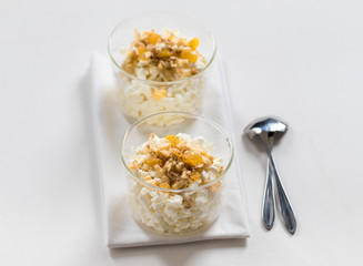 Crumbly cottage cheese with honey, banana, golden raisins and nuts on a light background