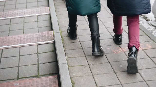 Two girls run merrily down the street. Close-up of Gog. Slow motion.