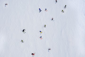 Aerial drone view on skiers on ski slope at winter. - Powered by Adobe