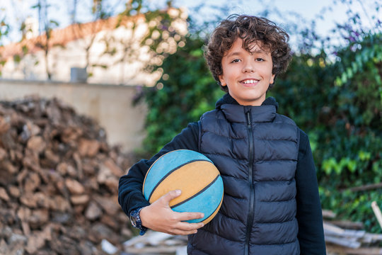 boy looking at camera holding a basketball