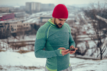 Athletic man taking a break from training and watching videos