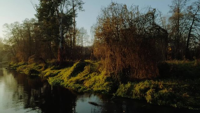 Scenic video of Polish river Wkra at sunset with gentle mist rising above water, almost fantasy scenery. Drone, aerial shot. Cinematic grading.