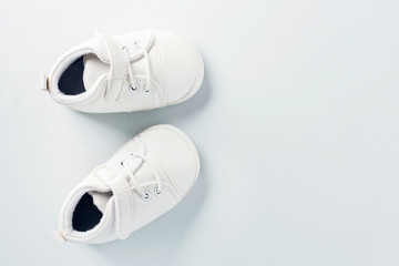 Tiny baby shoes on pastel background
