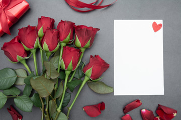 Valentine's Day, red roses, gift boxes and blank paper, over pinkl background flat lay, birthday abstract background with copy space.