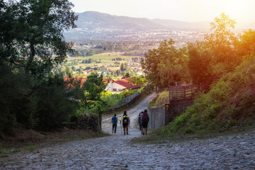 A group of pilgrims walking the camino de santiago at sunset. On a way to Santiago de Compostela. 