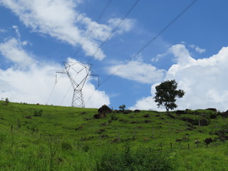 power transmission tower installed in the middle of green field in rural area