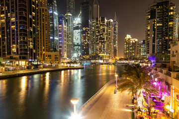 Fototapeta na wymiar Night view on Dubai Marina, skyscrapers, lights, promenade, Strait. Taken at slow shutter speeds.