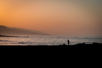 atardecer mar y pescador