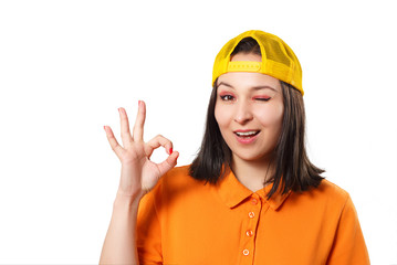 a girl woman in a bright Polo shirt shows a ok gesture and smiles