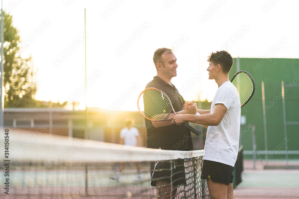 Wall mural Father and Son Playing Tennis Outdoors.