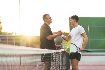 Father and Son Playing Tennis Outdoors.