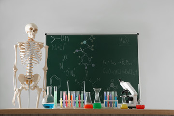 Skeleton and different chemistry glassware in classroom
