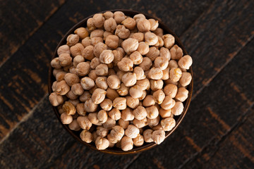 Bowl of Dry Chickpeas on a Rustic Wooden Table