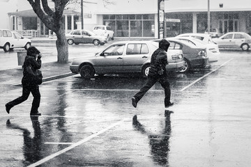 Obraz premium Ludzie biegający w deszczu czarno-białe