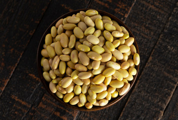 Bowl of Dry Mayocoba Beans on a Rustic Wooden Table