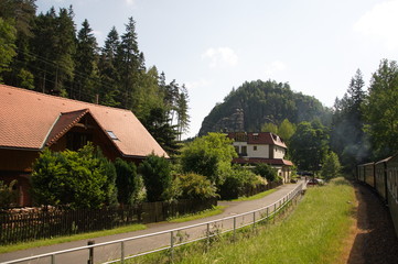 Fototapeta na wymiar Retro steam train passes a mountain resort in Germany.