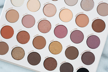 Neutral eyeshadow makeup palette on marble background