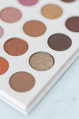 Neutral eyeshadow makeup palette on marble background