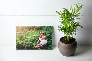 Canvas print on white table, front view. Photo with gallery wrap method of canvas stretching on...
