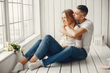 Obraz premium Para siedzi w domu. Piękna blondynka z mężem. Mężczyzna w białej koszuli