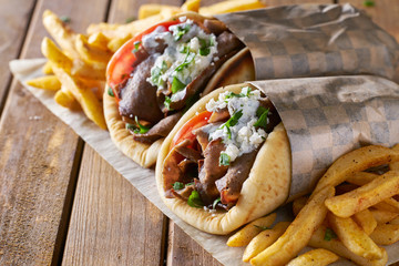 two greek gyros with shaved lamb and french fries