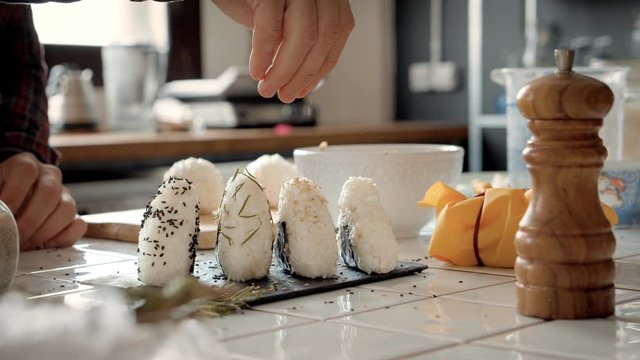 Chef or cook makes japanese onigiri snack recipe