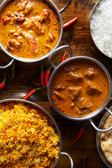 assortment of indian curries and rice dishes in flat lay composition