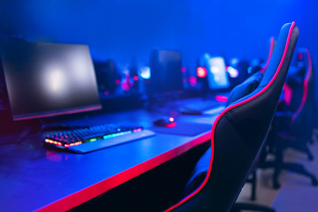 Workplace for professional gamer in computer games, online tournaments, comfortable chair, backlit keyboard, monitors, blue and red backgrounds © Parilov