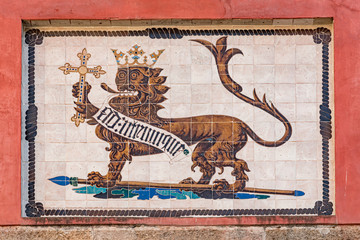 Fototapeta premium Painted and tin-glazed ceramic tiles of the Lion Gate in the Royal Alcazar of Seville. Close-up detail of the heraldic symbol of the Reign of Seville, Spain