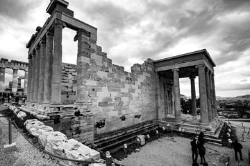 Athens, Greece - Decemeber 31 2019:  black and white image of tourists  near the Old Temple of Athena and the Erechtheion or Erechtheum an ancient Greek temple on the Acropolis of Athens