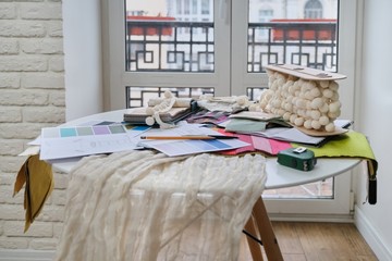 Workplace of textile designer, on the desk palettes with fabrics