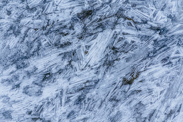 Ice texture, interesting frozen lake patterns, naturally created forms. Frozen river's water in the winter in mount Vitosha, near Sofia, Bulgaria. Ice Age climate changes.