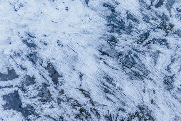 Ice texture, interesting frozen lake patterns, naturally created forms. Frozen river's water in the winter in mount Vitosha, near Sofia, Bulgaria. Ice Age climate changes.