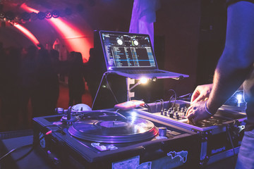 Closeup dj turn table, with people dancing in the background