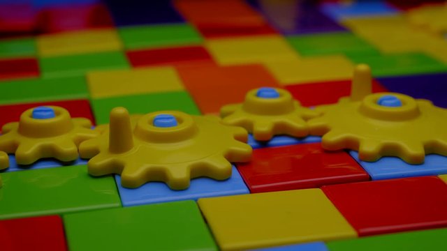 TODDLER'S BUILDING BLOCKS WITH TURNING GEARS.  4K, ECU.  NO PEOPLE.