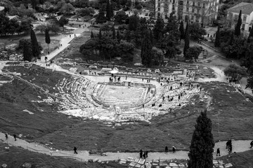 Athens, Greece - Decemeber 31 2019: black and white photo of tourists visit the Theatre of Dionysus Eleuthereus, a major theatre in Athens, built at the foot of the Athenian Acropolis