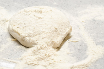 Italian national pizza in the process of cooking. soft lush dough with wheat flour on the table. copy space