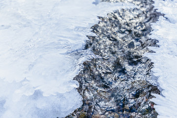 Ice texture, interesting frozen lake patterns, naturally created forms. Frozen river's water in the winter in mount Vitosha, near Sofia, Bulgaria. Ice Age climate changes.