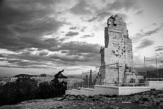 black and white photo of the Philopappu Monument and the Parthenon in background, Greek mausoleum dedicated to Gaius Julius Antiochus Epiphanes Philopappos or Philopappus in Athens, Greec