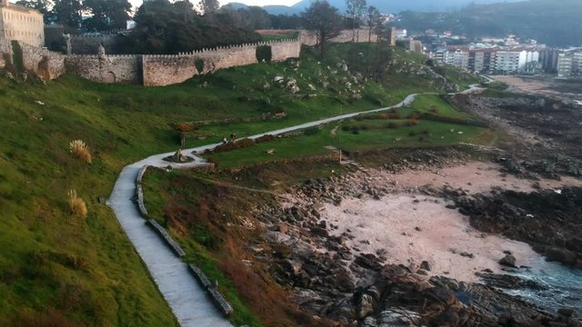 Drone flight above the walking path of the Baiona Parador Castle in Galicia, Spain