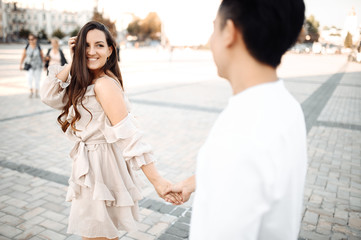 Naklejka premium Couple in love walks around the city. Girl looks at her boyfriend with love and smiling