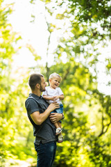 Fototapeta premium Father and son having fun in summer park. Family concept.