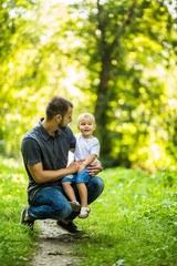 Fototapeta premium Father and son having fun in summer park. Family concept.