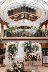 Wedding table serving. Wedding luxury decor. Wedding presidium for the newlyweds. Beautiful decor with pastel roses, candles and greenery. Indoors