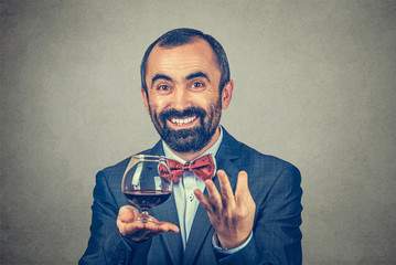 man with wine glass asking what do you say with hand gesture