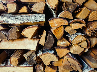 Old birch woodpile in a country house background / wallpaper.